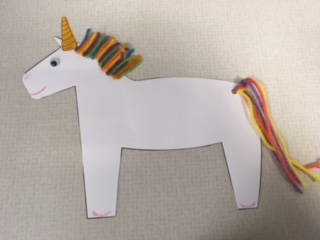 white unicorn with multicolored yarn mane and tail
