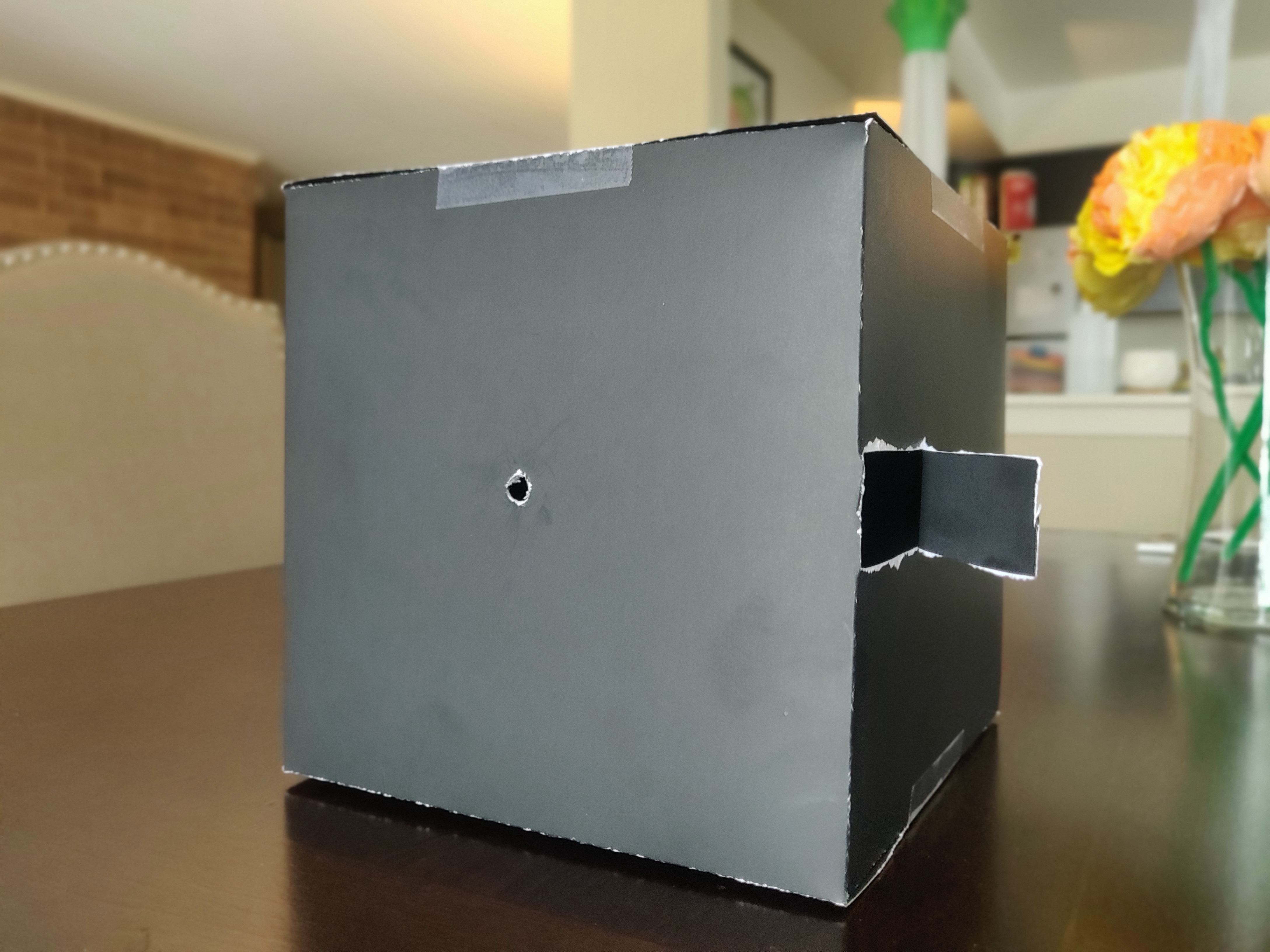 Pinhole camera made out of black poster board.