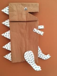 brown paper bag dinosaur with colored legs, arms & spikes.