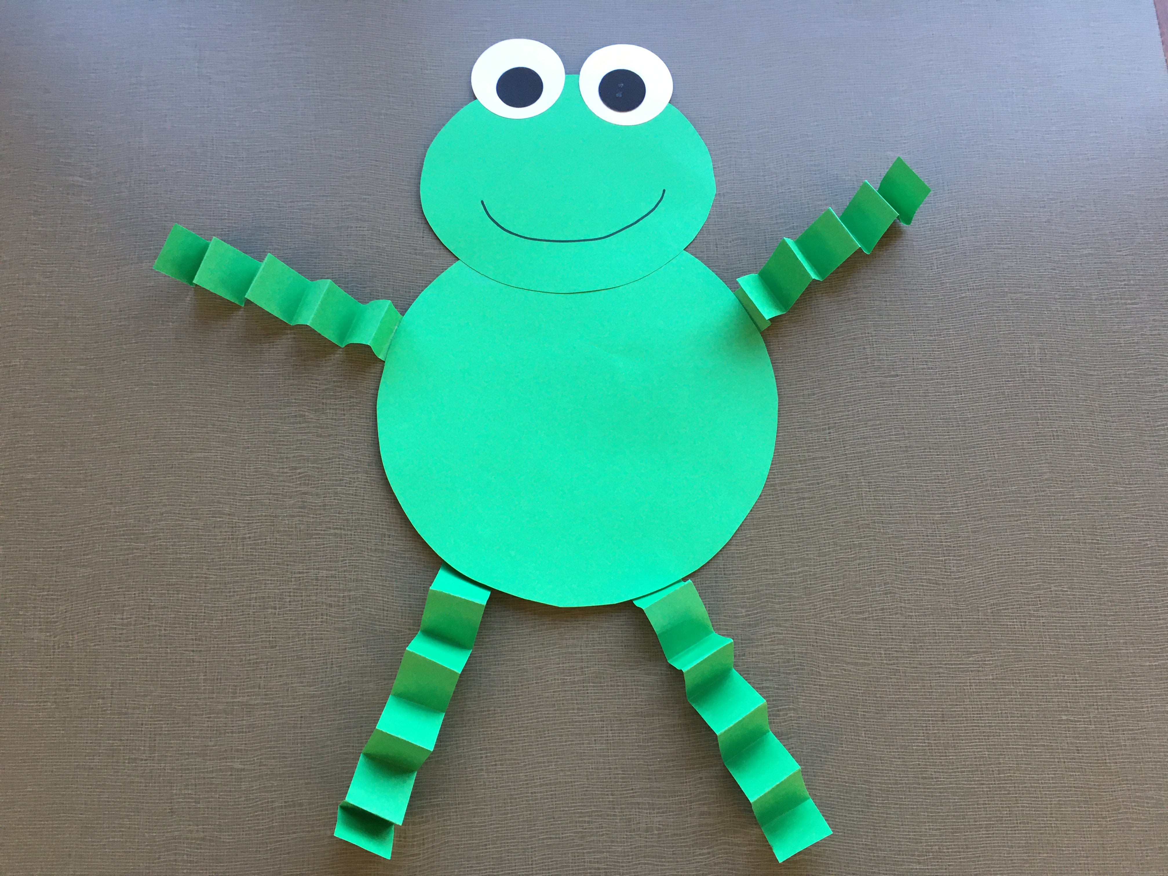 green paper frog with green accordion-fold arms and legs