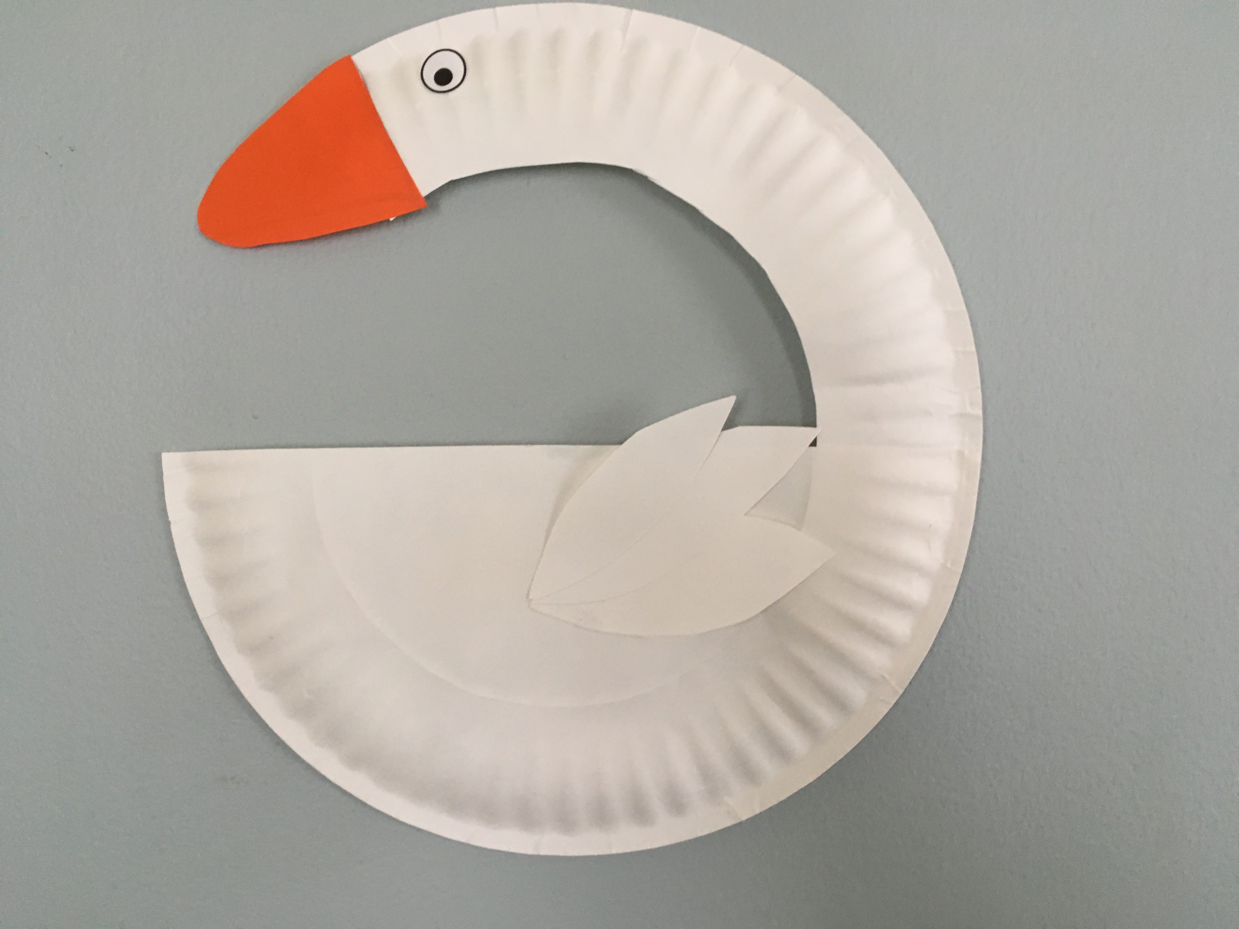 paper plate swan with orange beak and white feathers