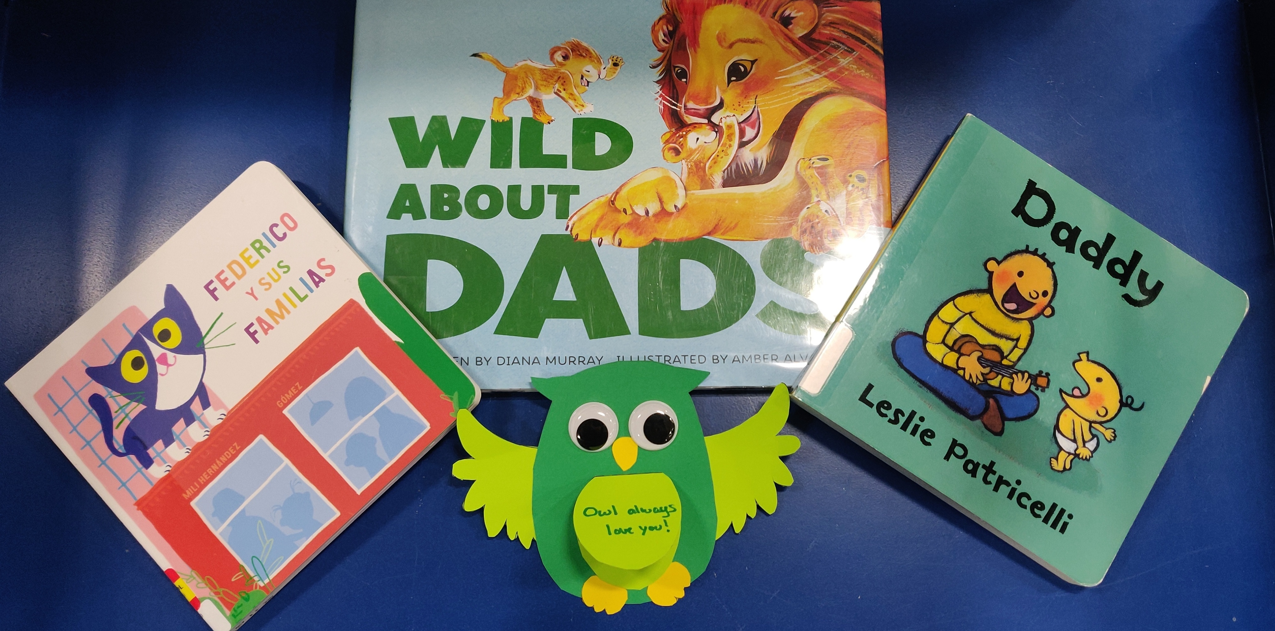 Photo of books about families and dads with a card of an owl.