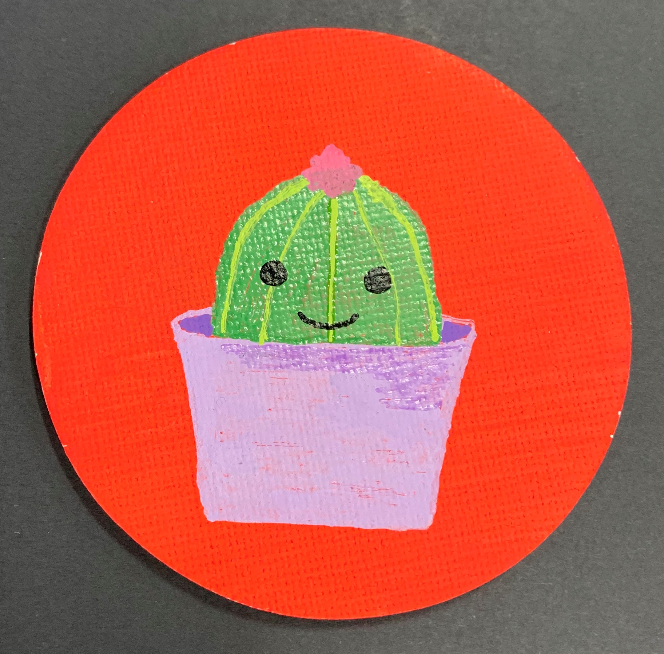 Painting of a cactus with a smiley face in bright colors