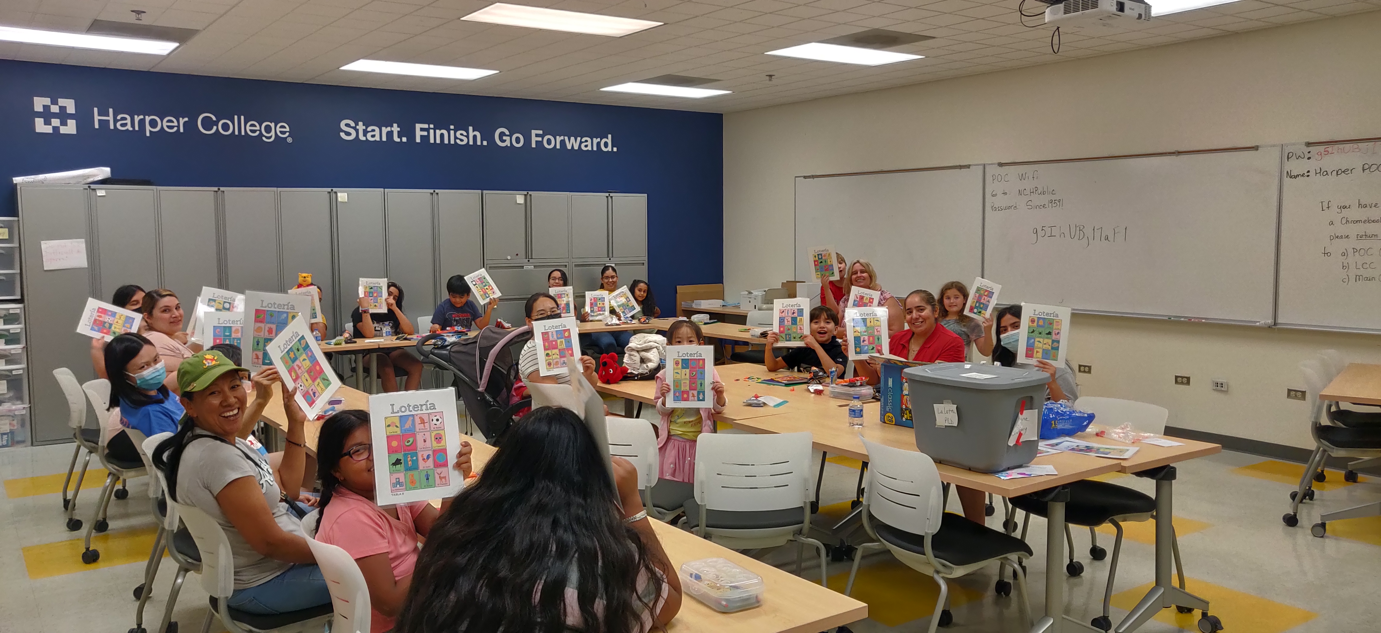 Families from Rand Road holding up their Loteria cards