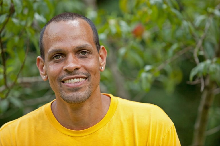 Head shot of Ross Gay wearing a yellow shirt