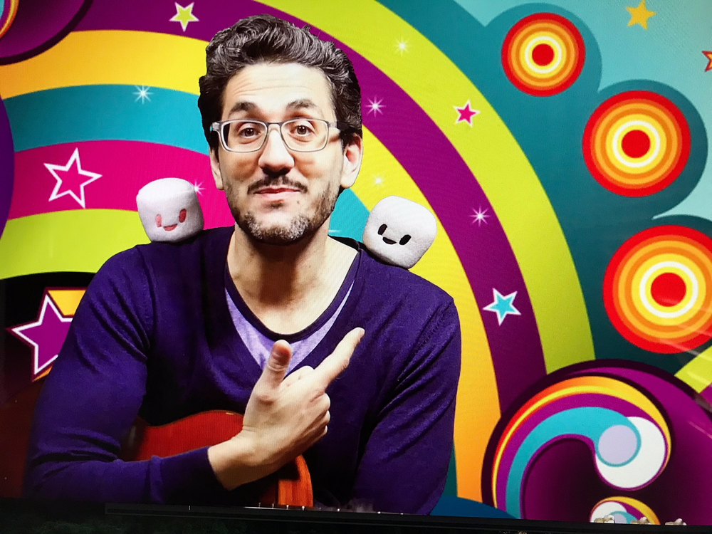 Istvan holding a guitar with a colorful background.