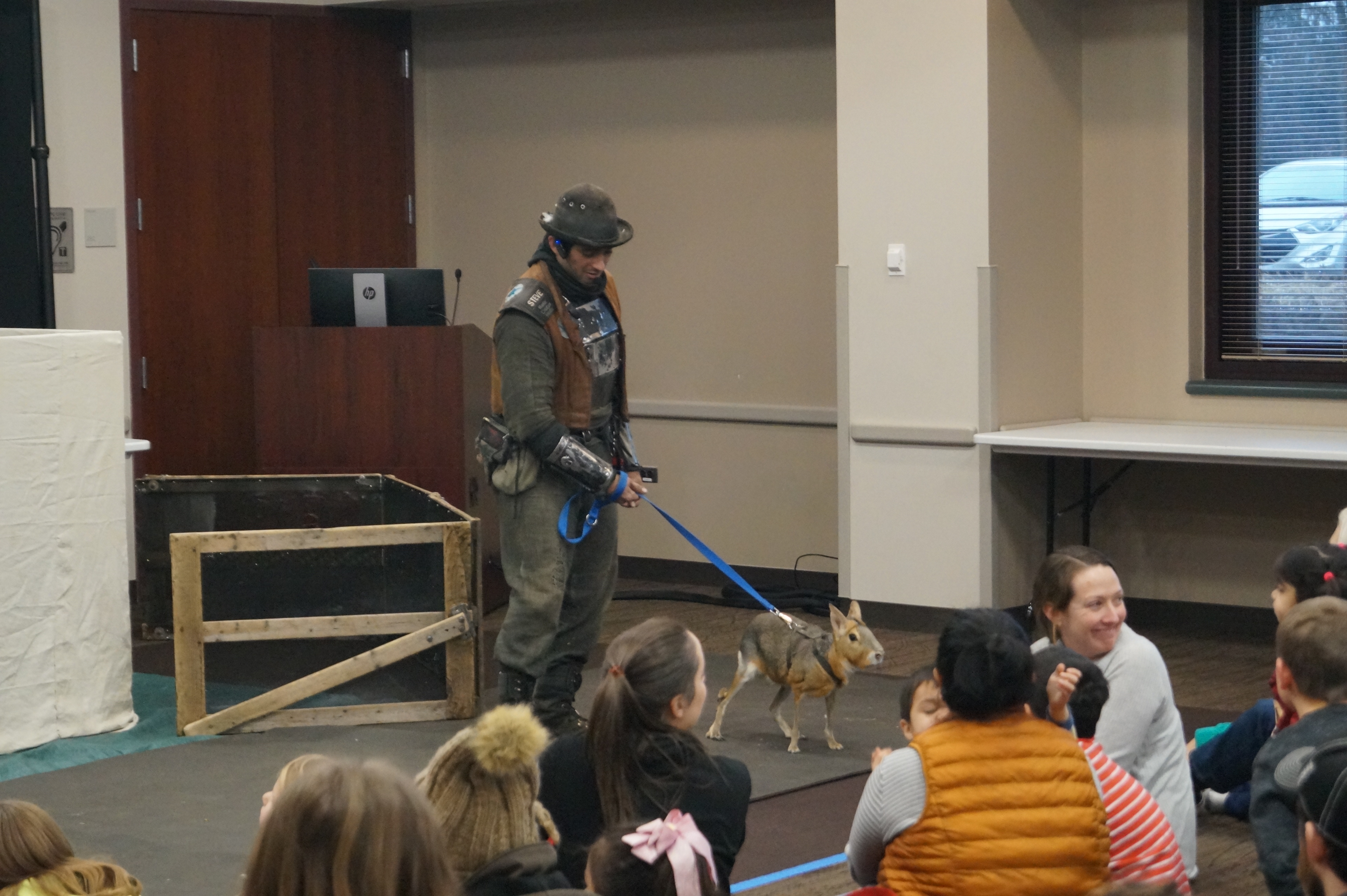 A member of the Animal Quest team walking an animal on a leash for kids to see.