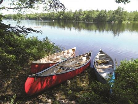 Photo of three canoes by a lake