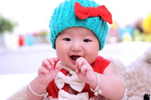 baby in blue hat with red bow