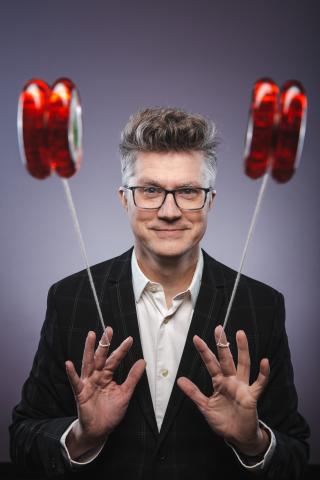 Presenter Mark Hayward throwing out two yo-yos at the camera