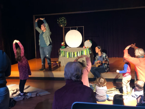 Lauren and Cindy of Firefly Family Theater going through an interactive story with kids while one plays the ukulele.