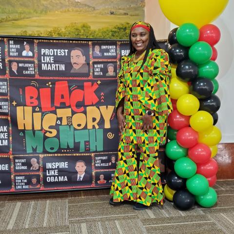 Picture of Elizabeth Kahura next to poster about Black History Month