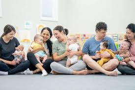 new parents sitting on the floor with their babies