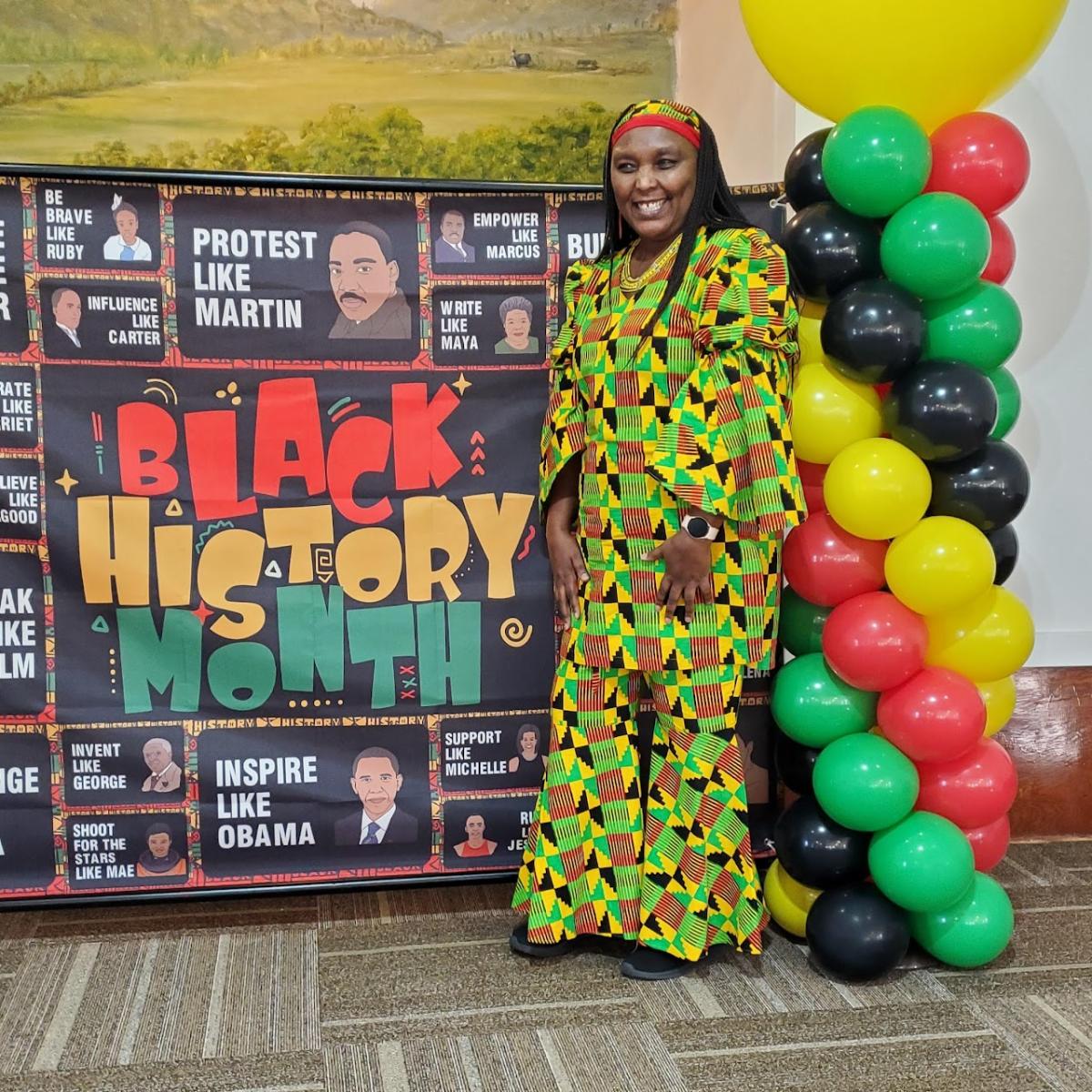 Picture of Elizabeth Kahura next to poster about Black History Month