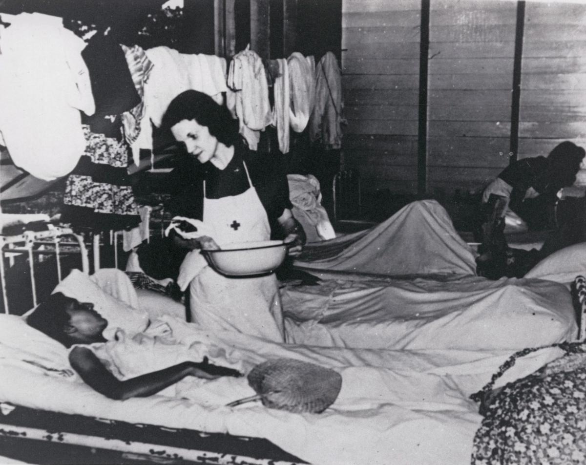Photo of Nurse Peg Nash with a patient inside infirmary at the Los Banos prison camp.